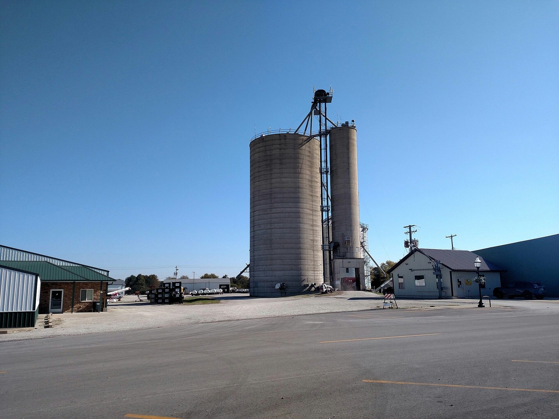 A concrete grain elevator with its headhouse standing over a rail siding